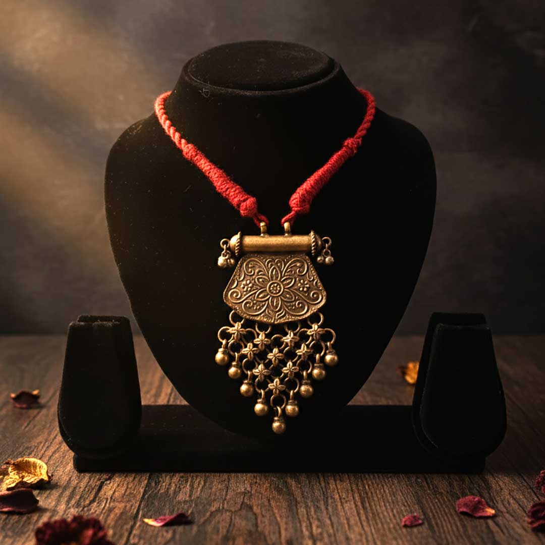 Decorative necklace with intricate design on a black stand against a dark background