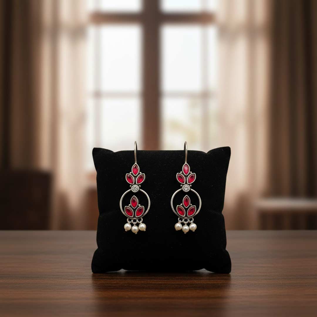 Pair of earrings on a black cushion with a blurred background