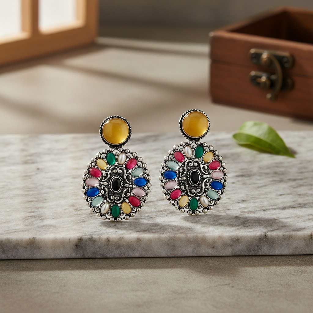Colorful earrings on a marble surface with a wooden box in the background