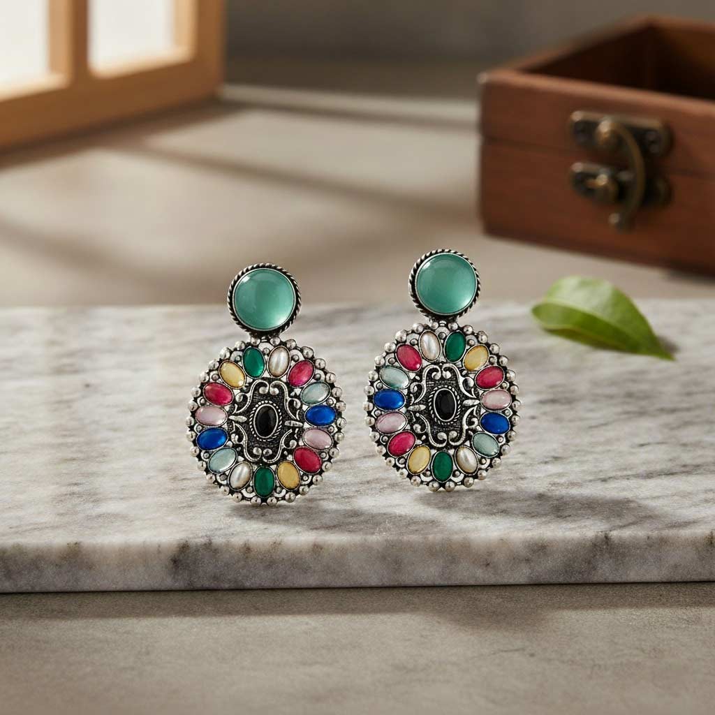 Colorful earrings on a marble surface with a wooden box in the background